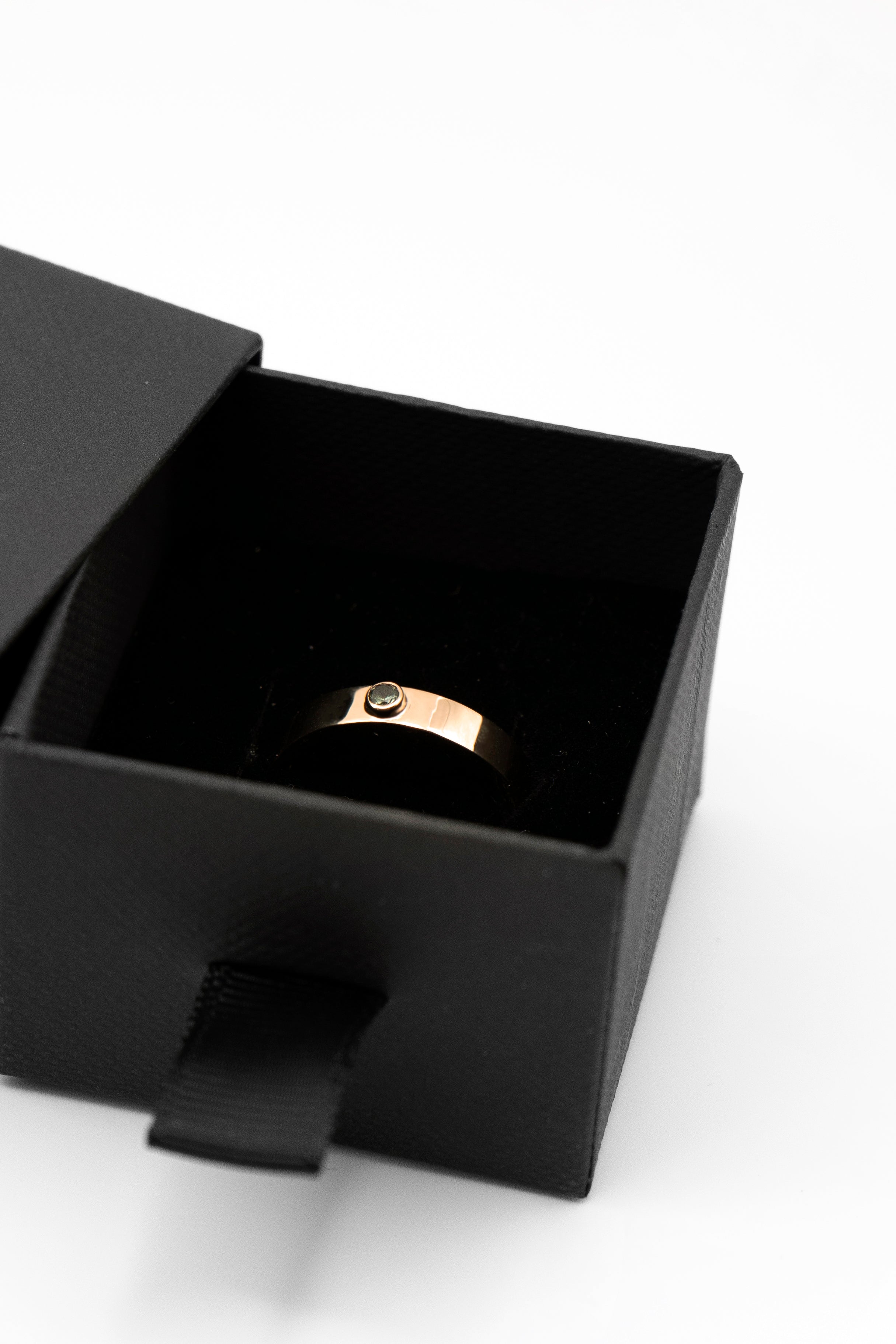 14k gold wedding band with bezel-set green sapphire