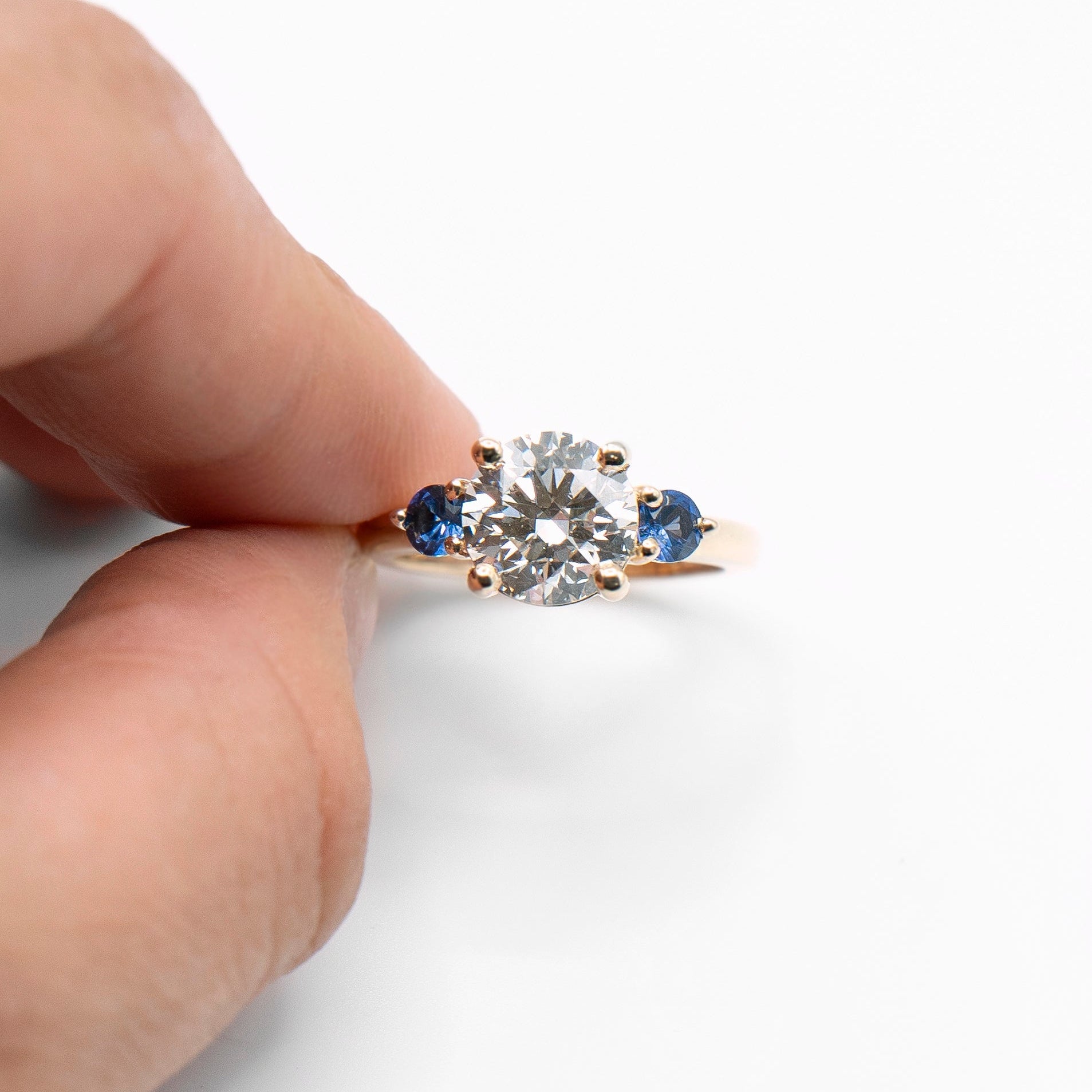 Round lab-grown diamond engagement ring with two sapphires
