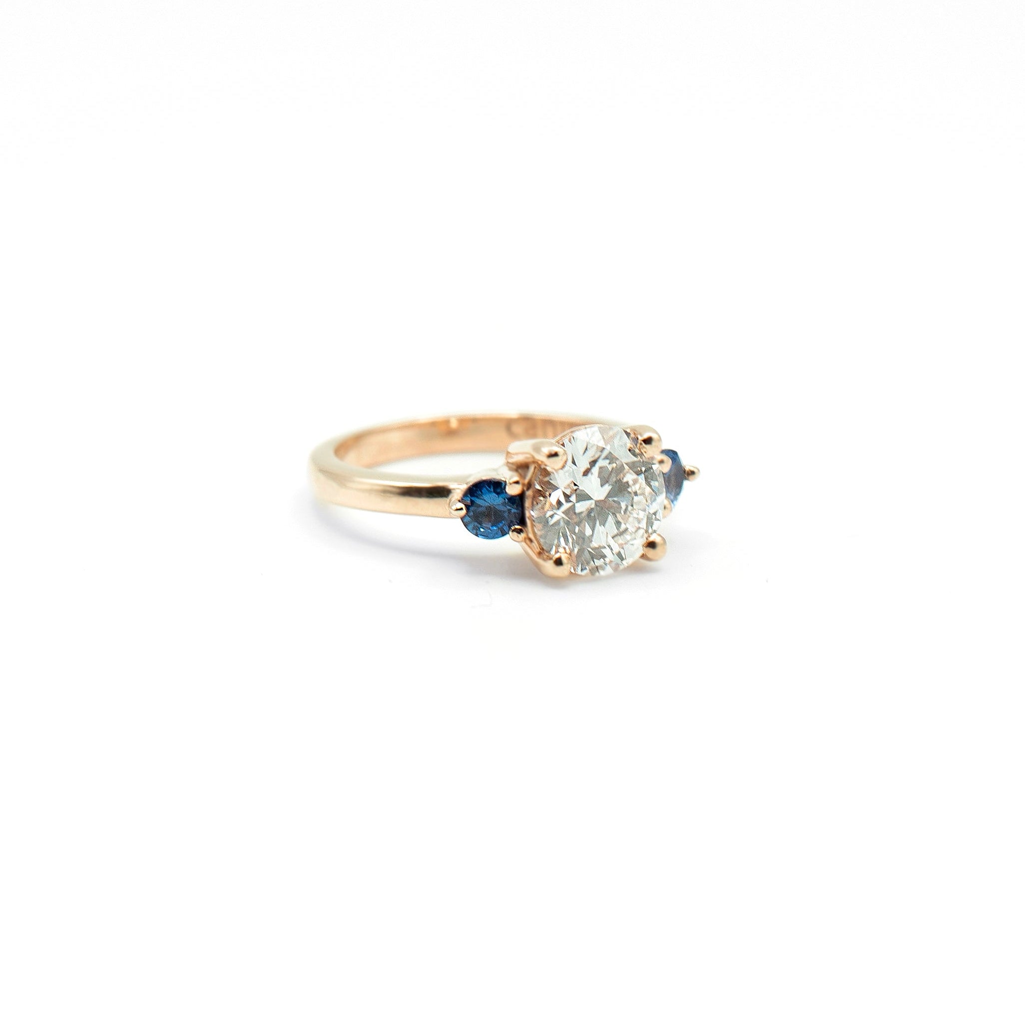 Round lab-grown diamond engagement ring with two sapphires