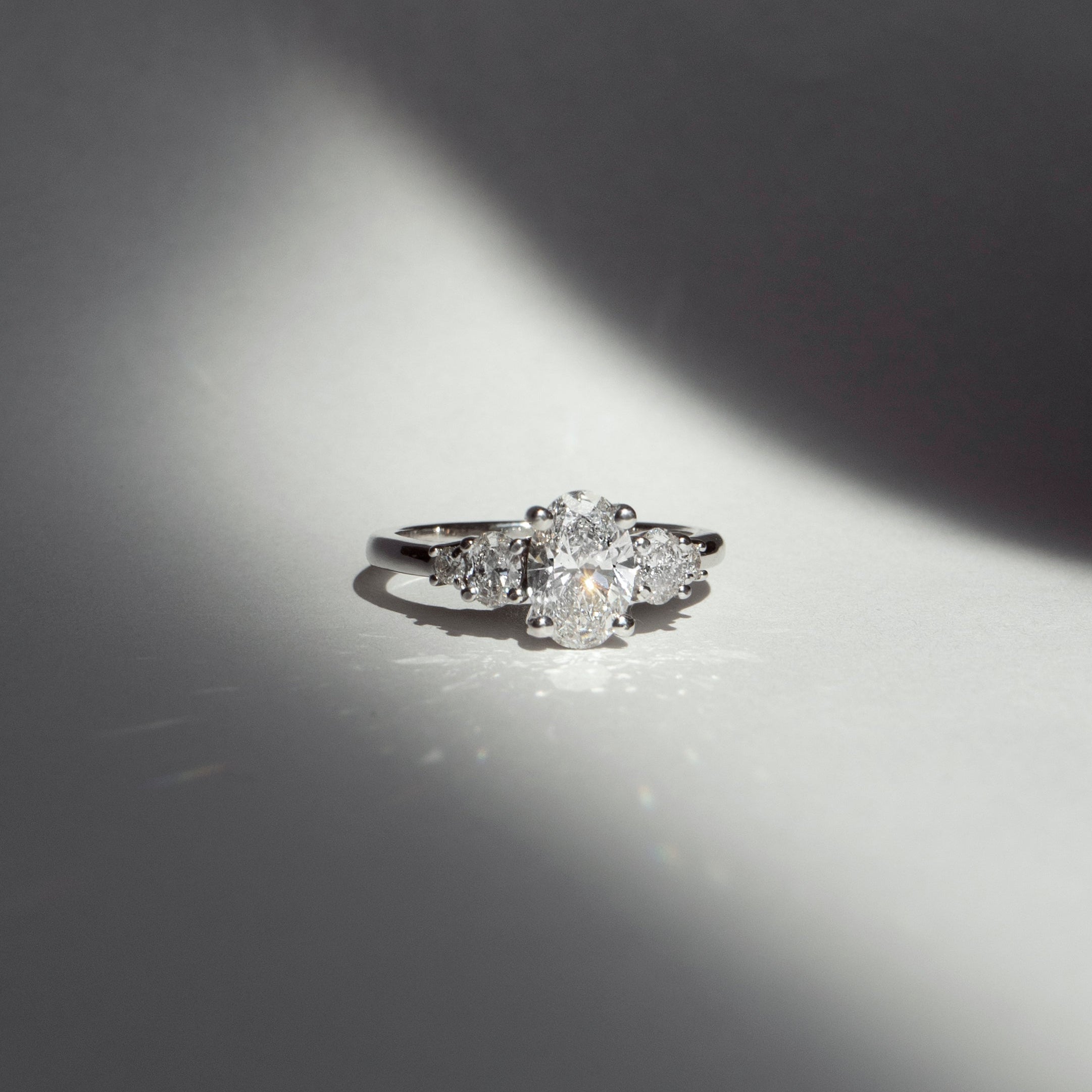 Oval diamond engagement ring with oval and round diamond accents