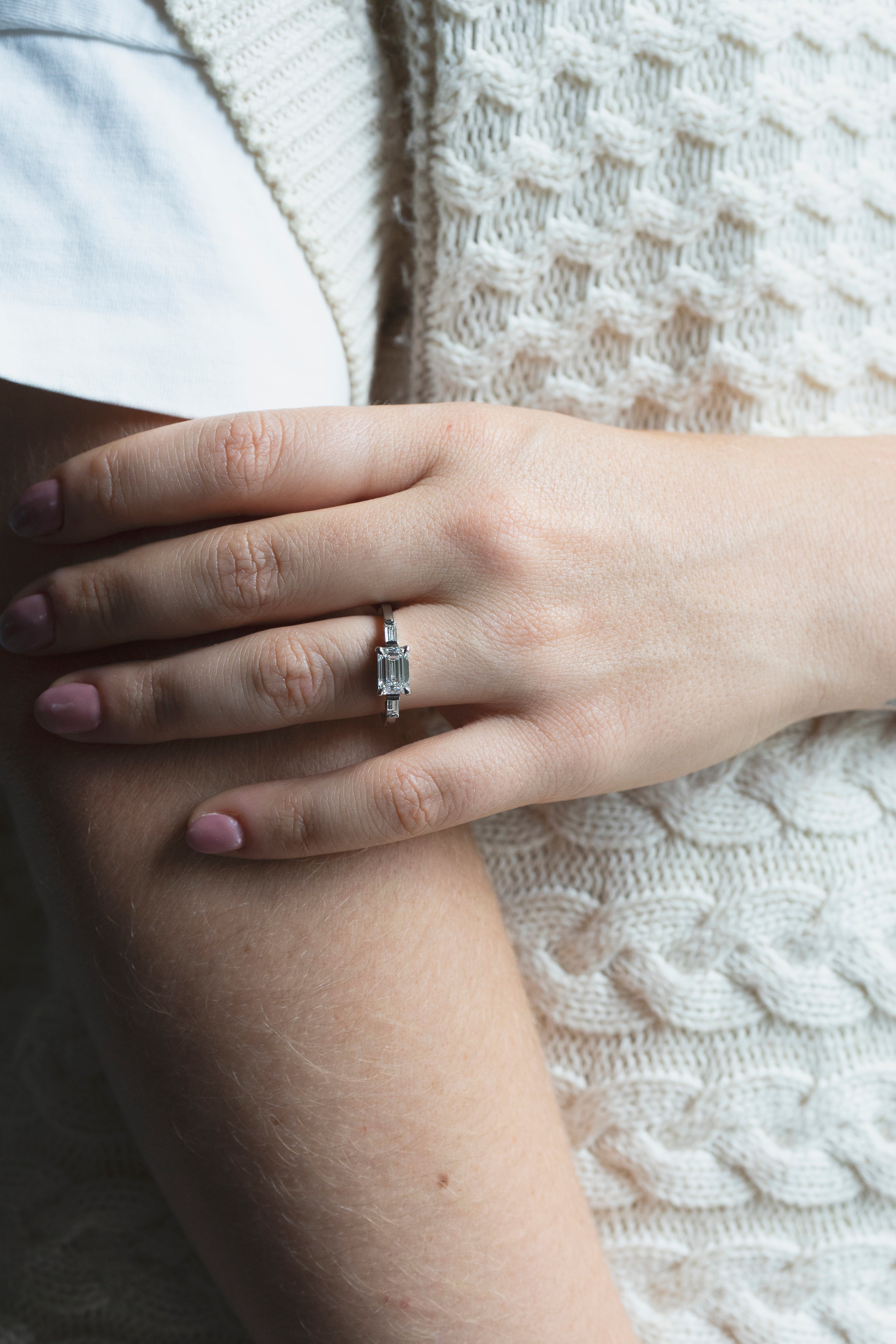 Emerald-cut diamond engagement ring set east-west with two baguette diamonds