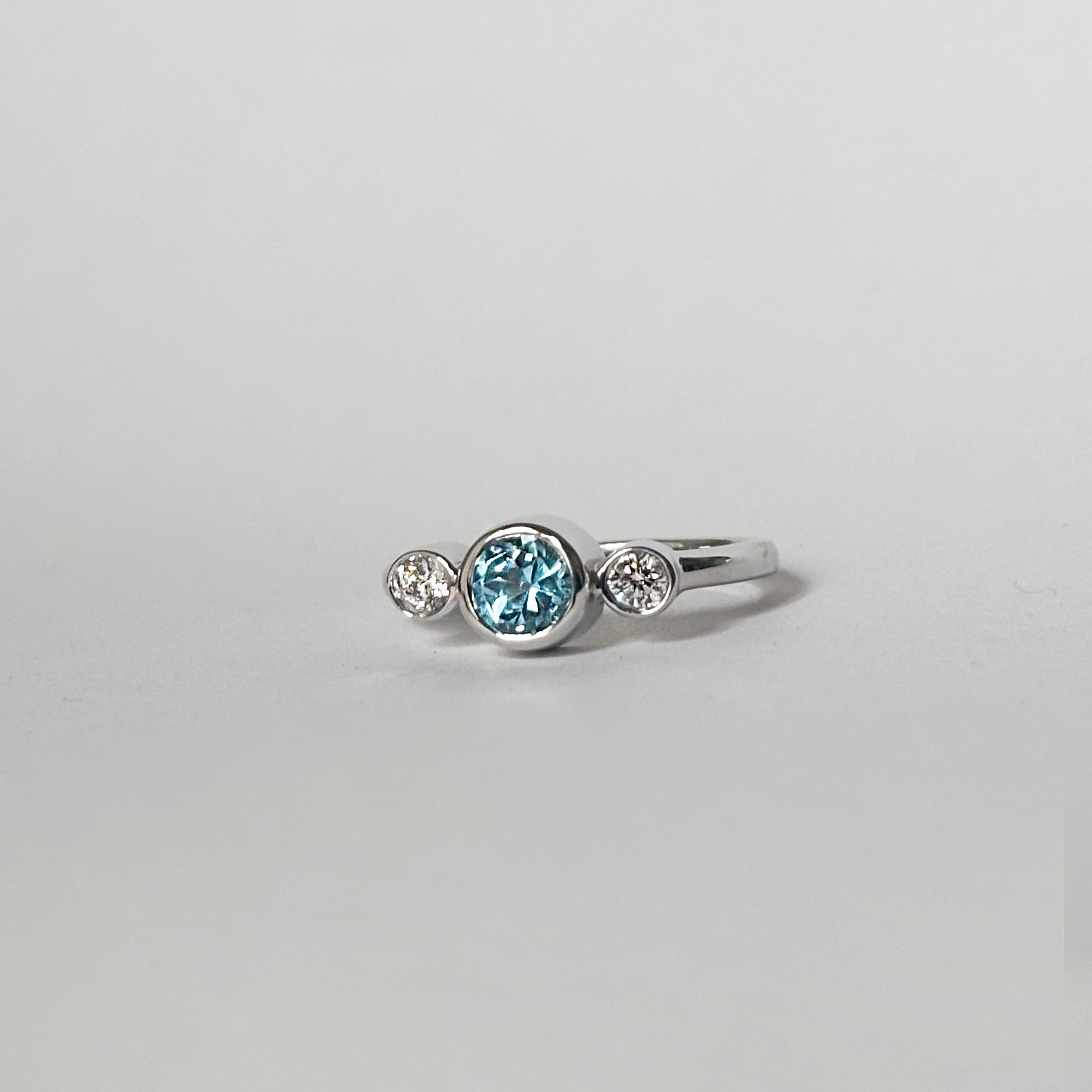 Round blue topaz and diamonds bezel ring