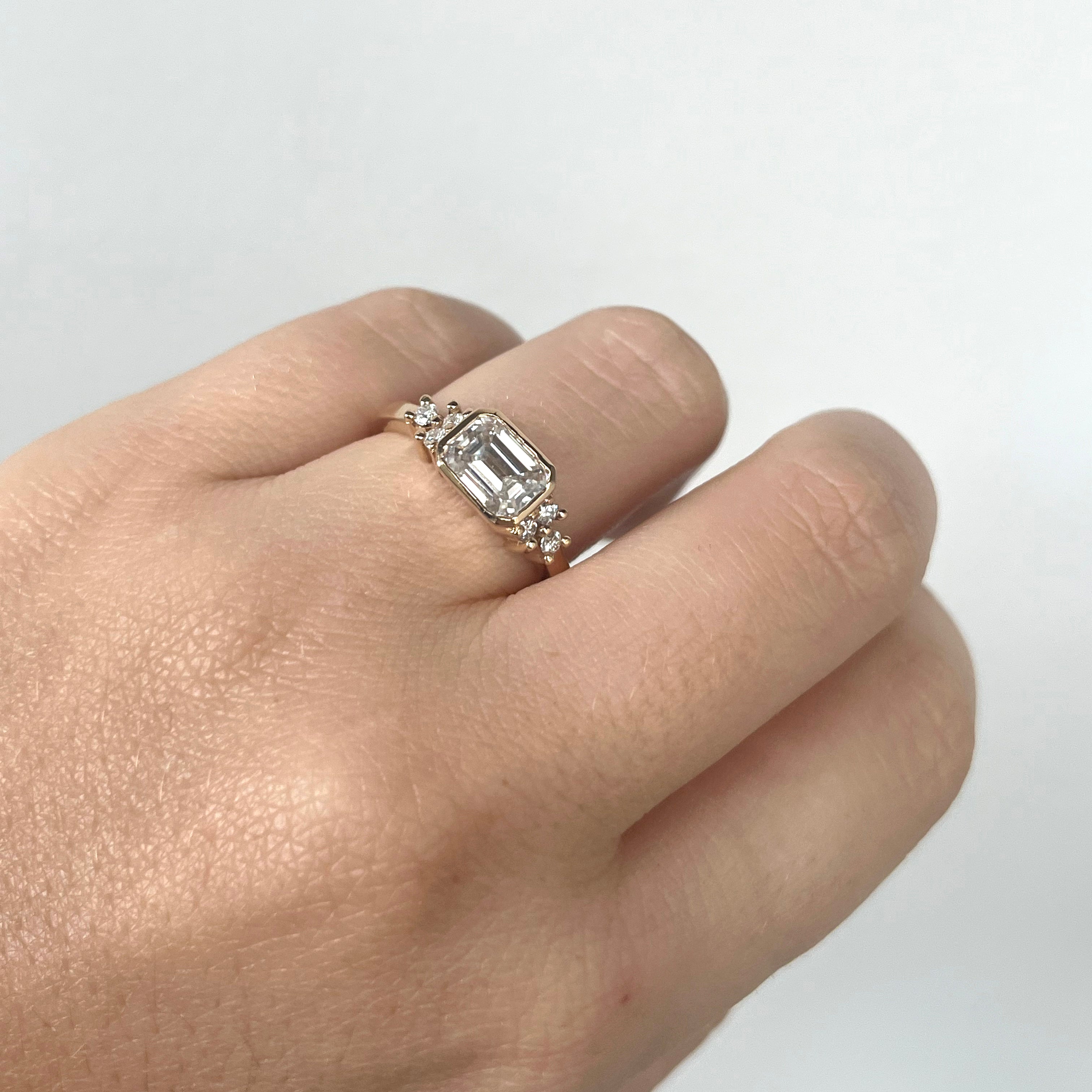 Anillo de compromiso con diamante corte esmeralda en bisel