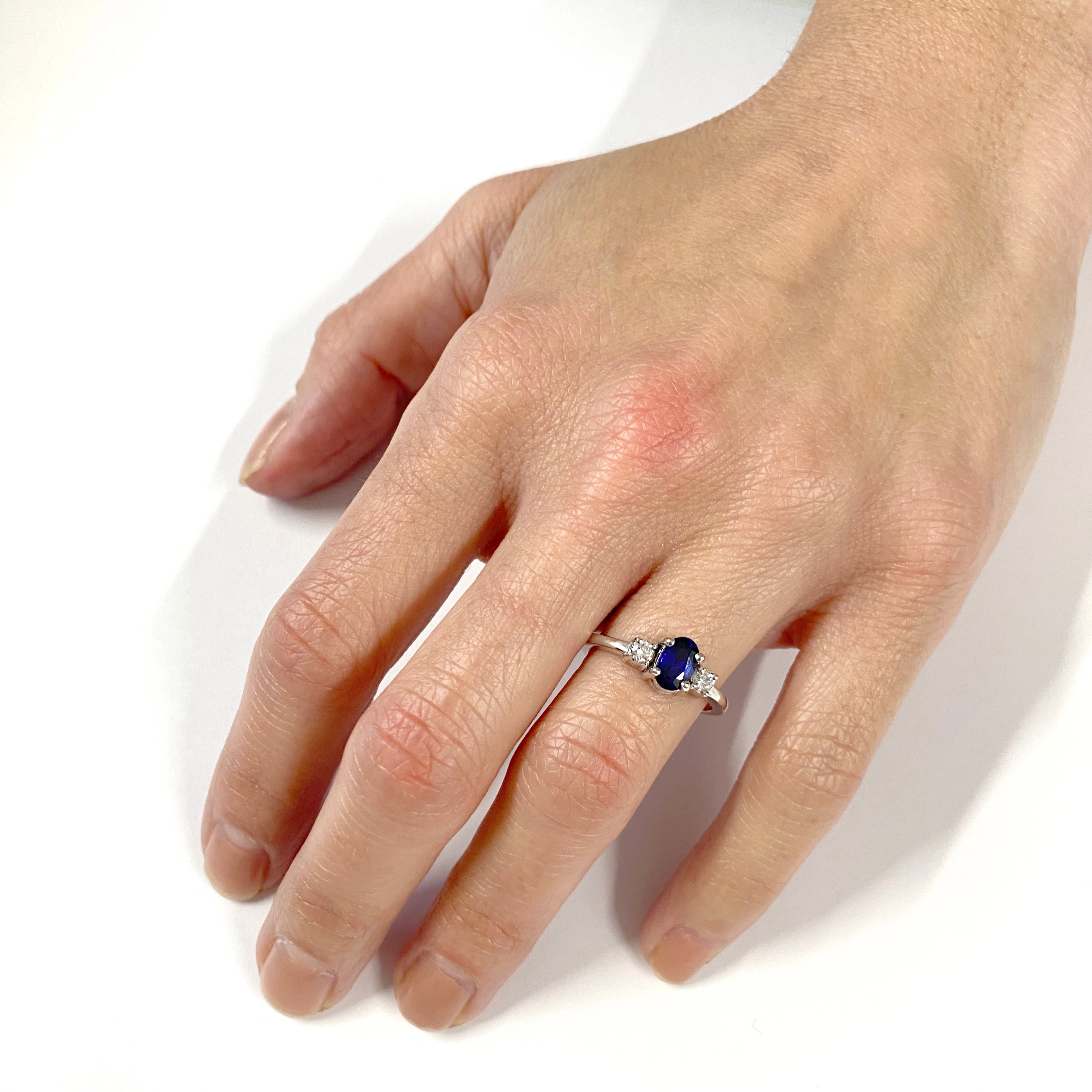 Anillo de compromiso con zafiro azul ovalado y dos diamantes