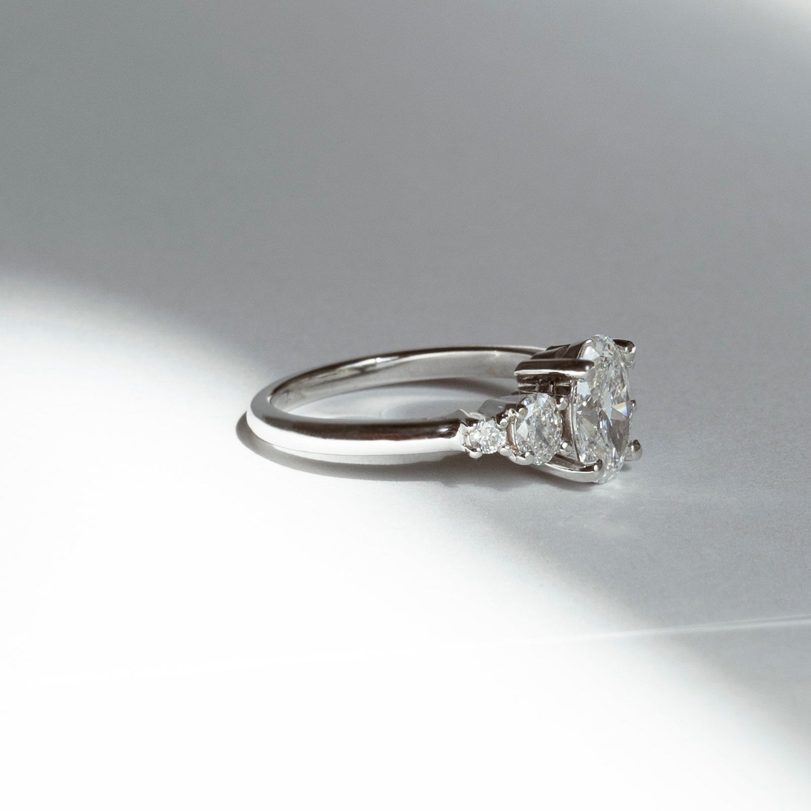 Oval diamond engagement ring with oval and round diamond accents