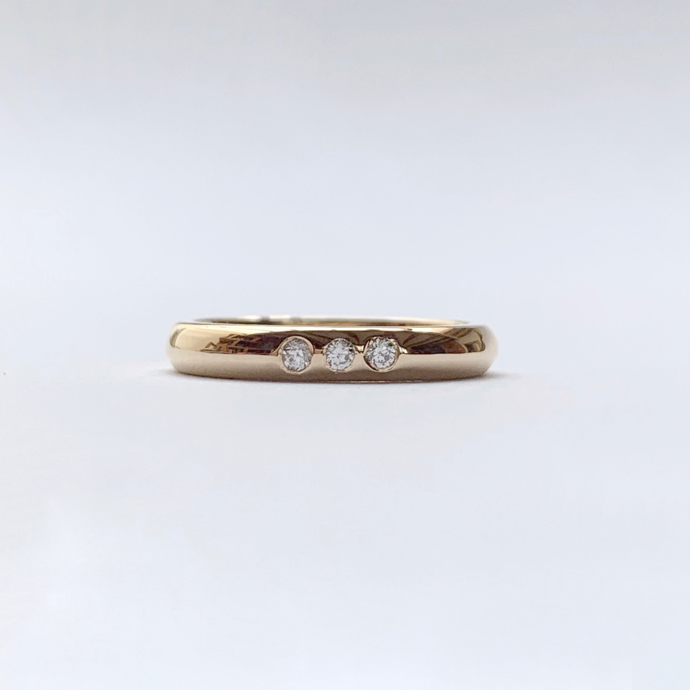 Yellow gold wedding band with three diamonds