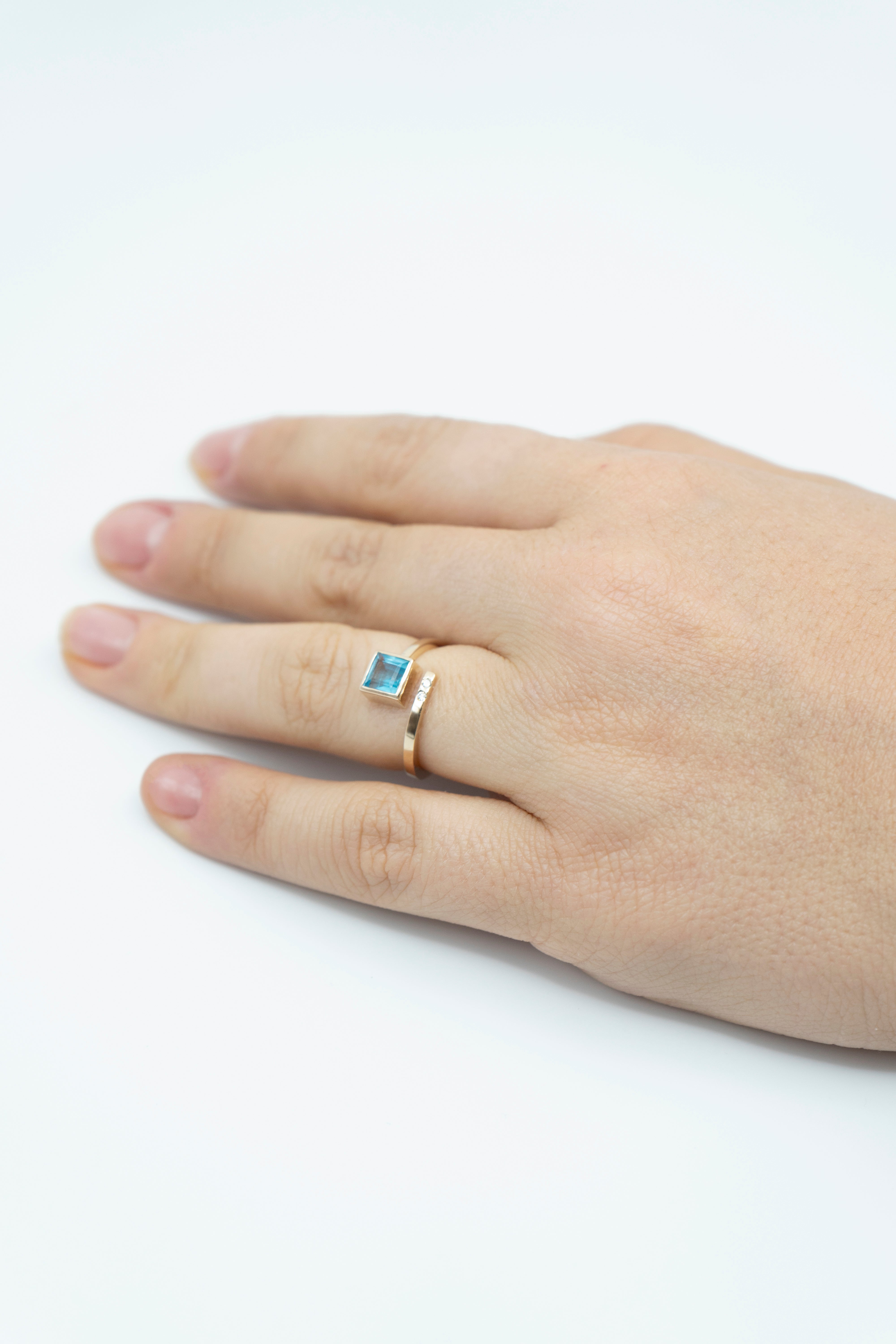 Anillo con topacio de corte cuadrado, banda en espiral y diamantes