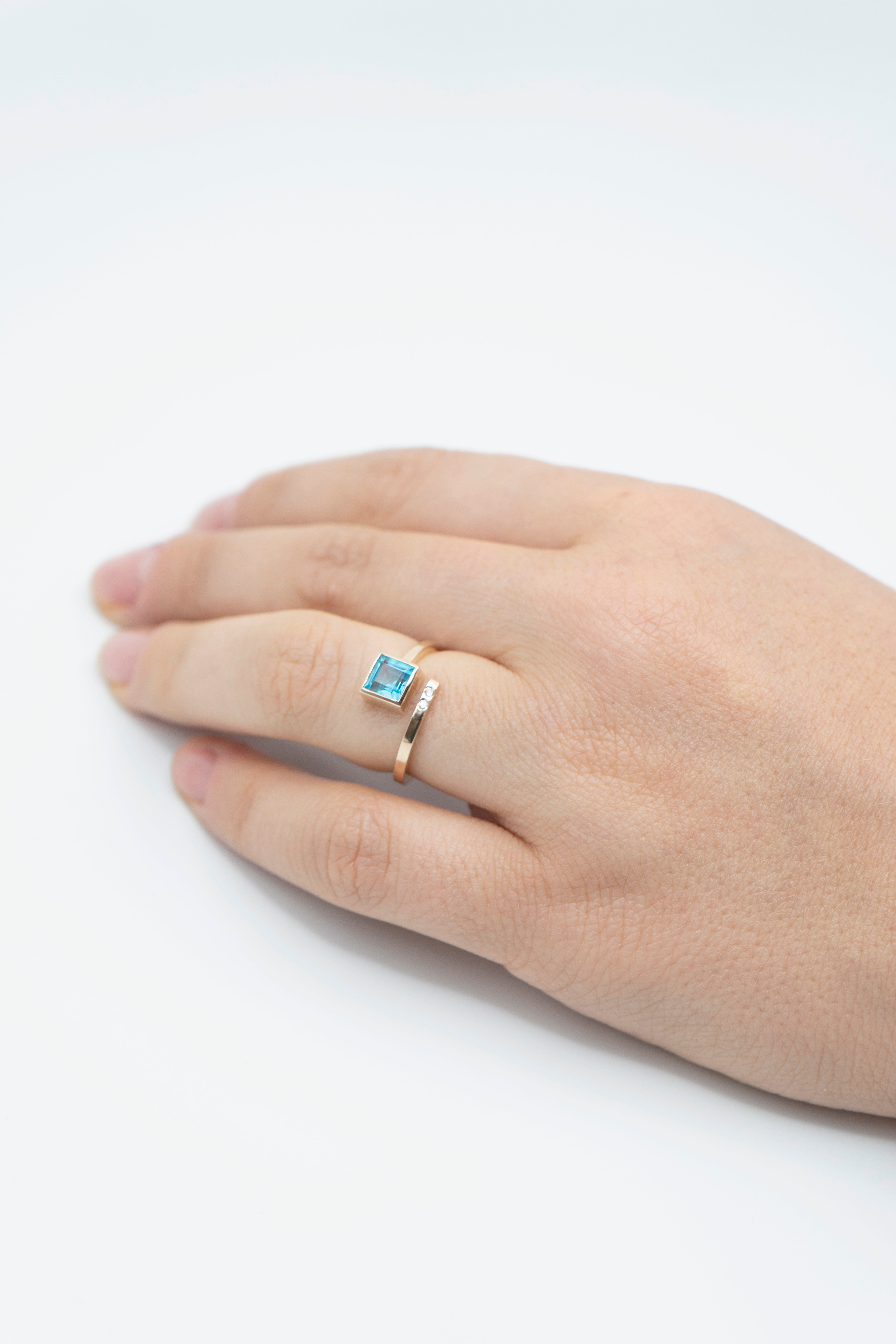 Anillo con topacio de corte cuadrado, banda en espiral y diamantes