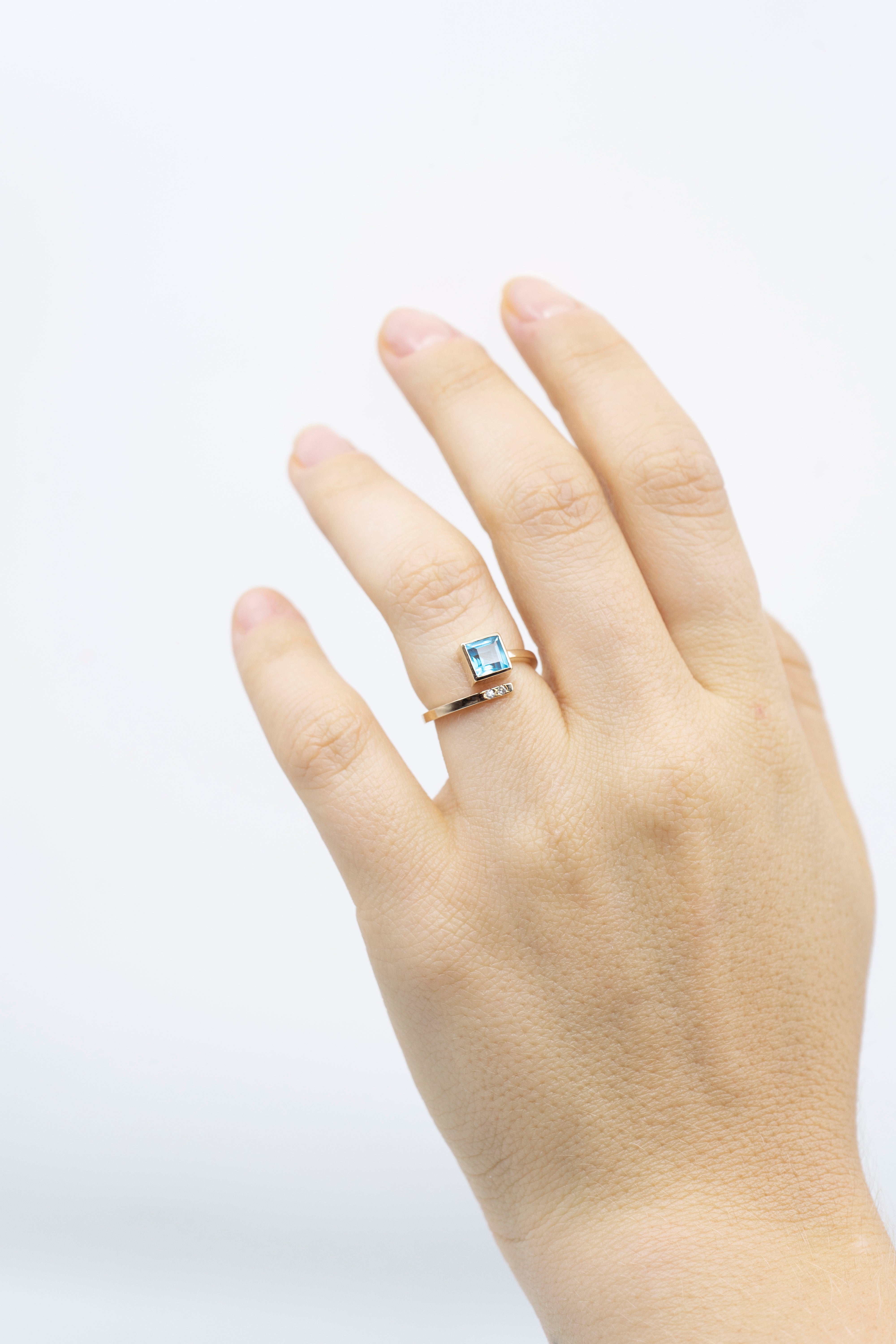 Anillo con topacio de corte cuadrado, banda en espiral y diamantes