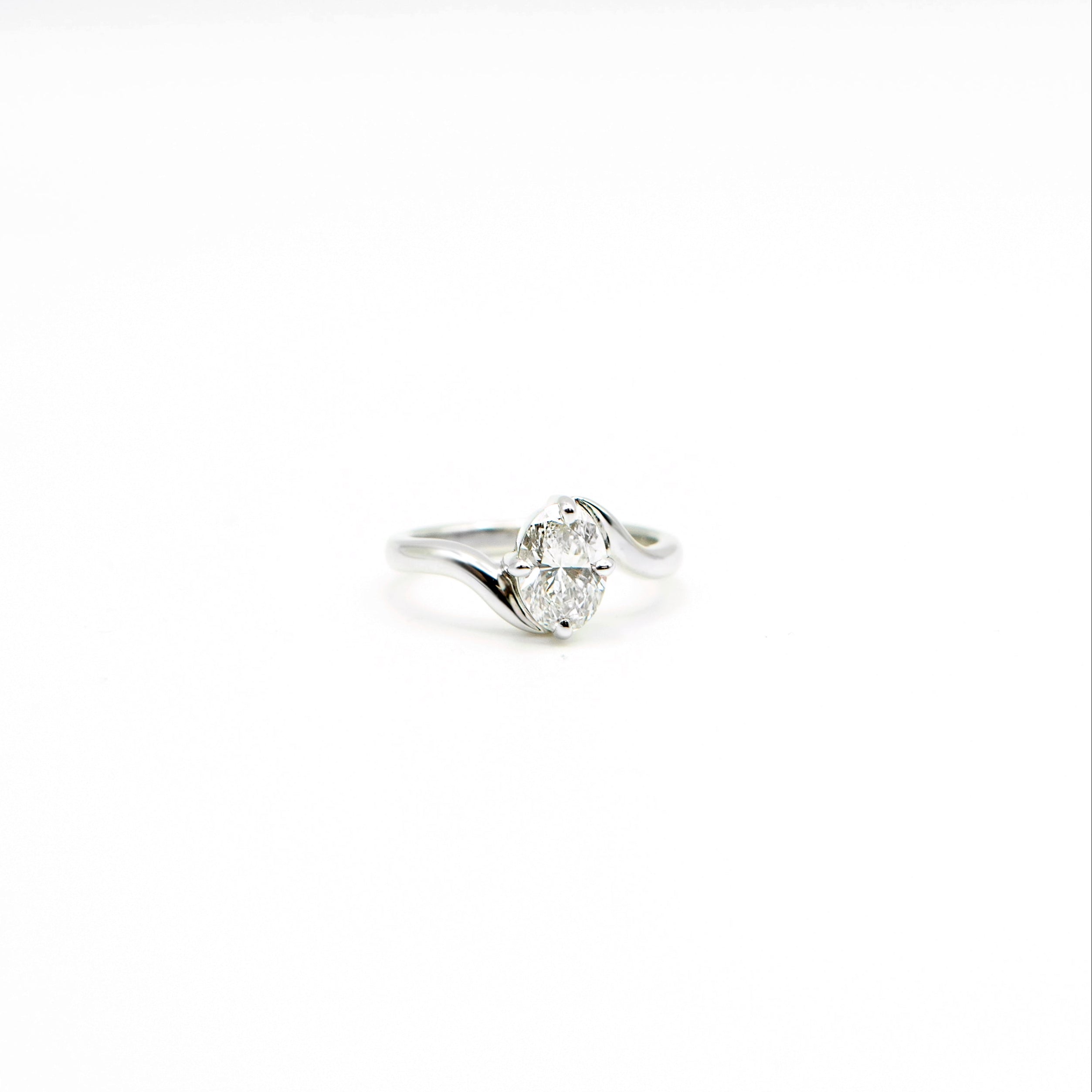 Anillo de compromiso en oro blanco con diamante ovalado y banda curveada