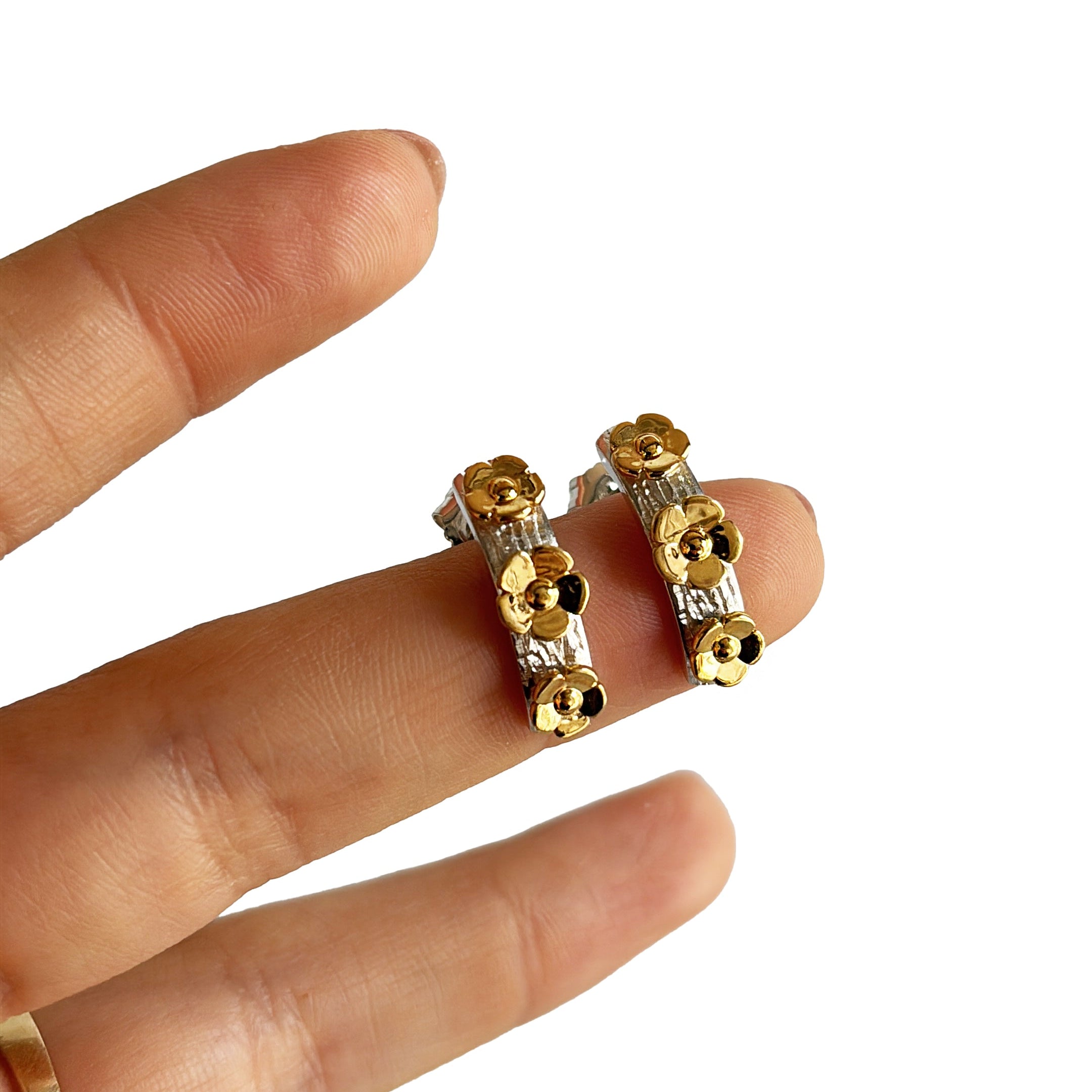 Aretes tipo stud de flor en plata y oro 14K