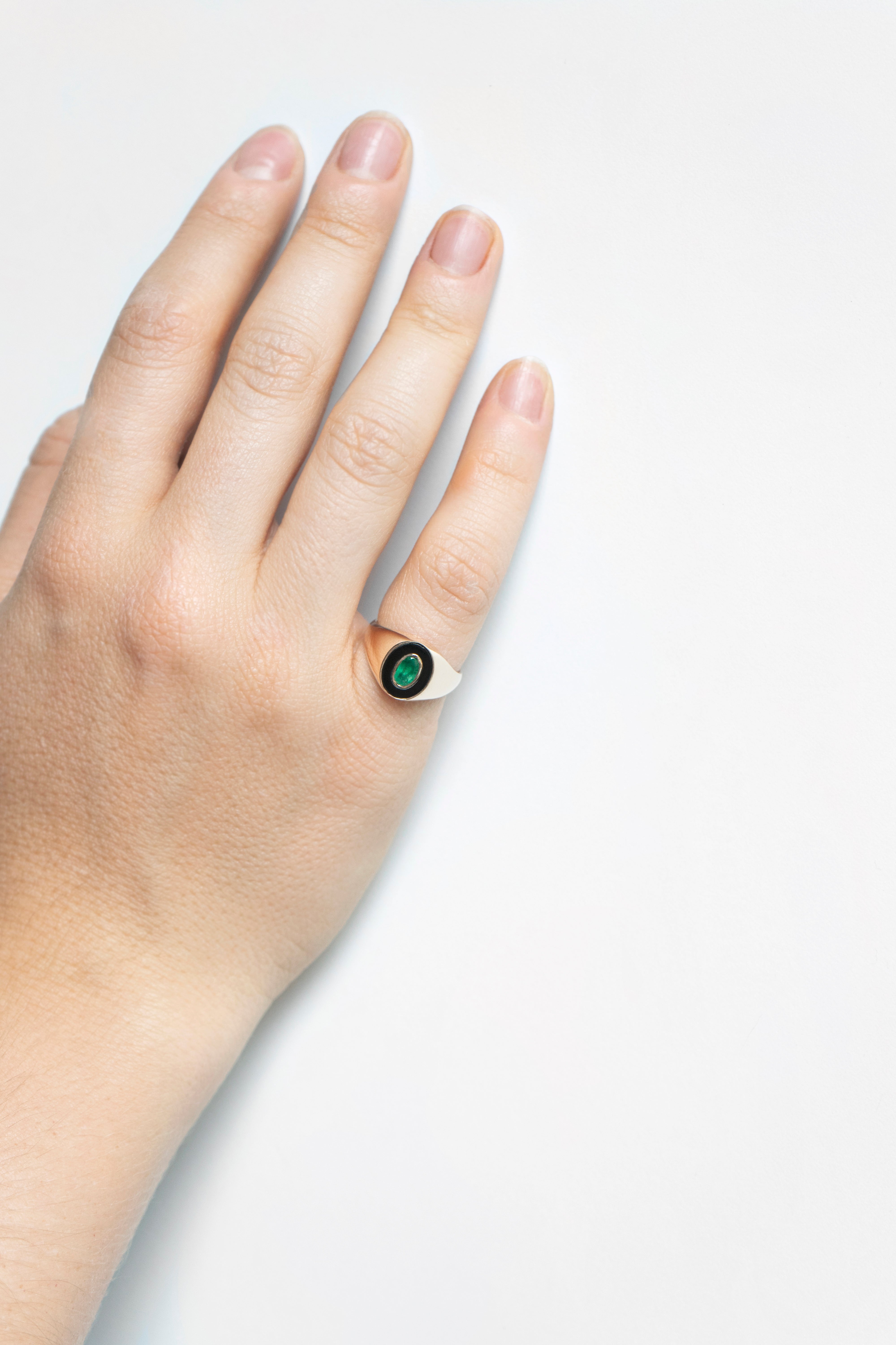 Anillo de sello de oro con ónix ovalado y esmeralda engastada en bisel