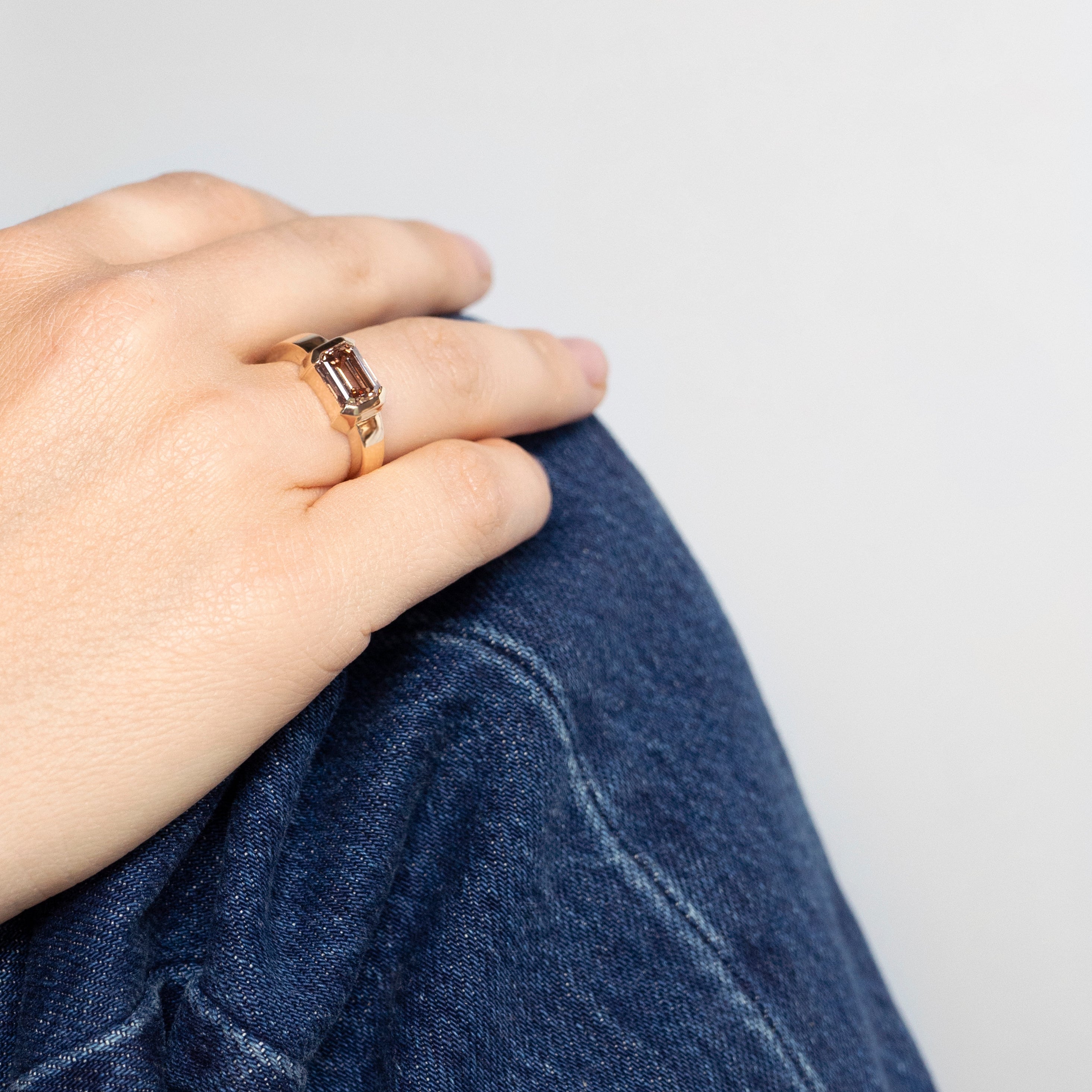 East-west emerald-cut fancy brown lab-grown diamond ring in half bezel