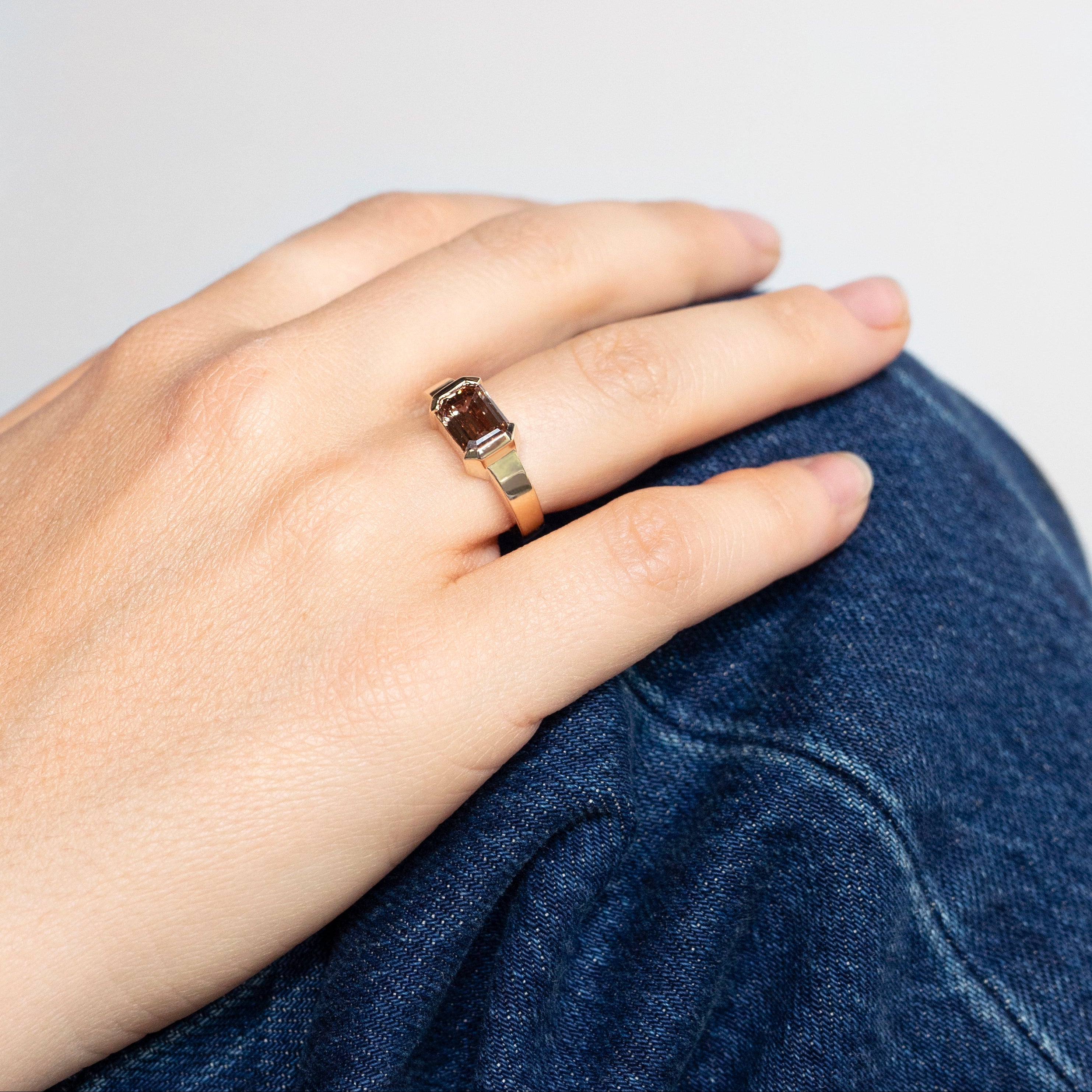 East-west emerald-cut fancy brown lab-grown diamond ring in half bezel