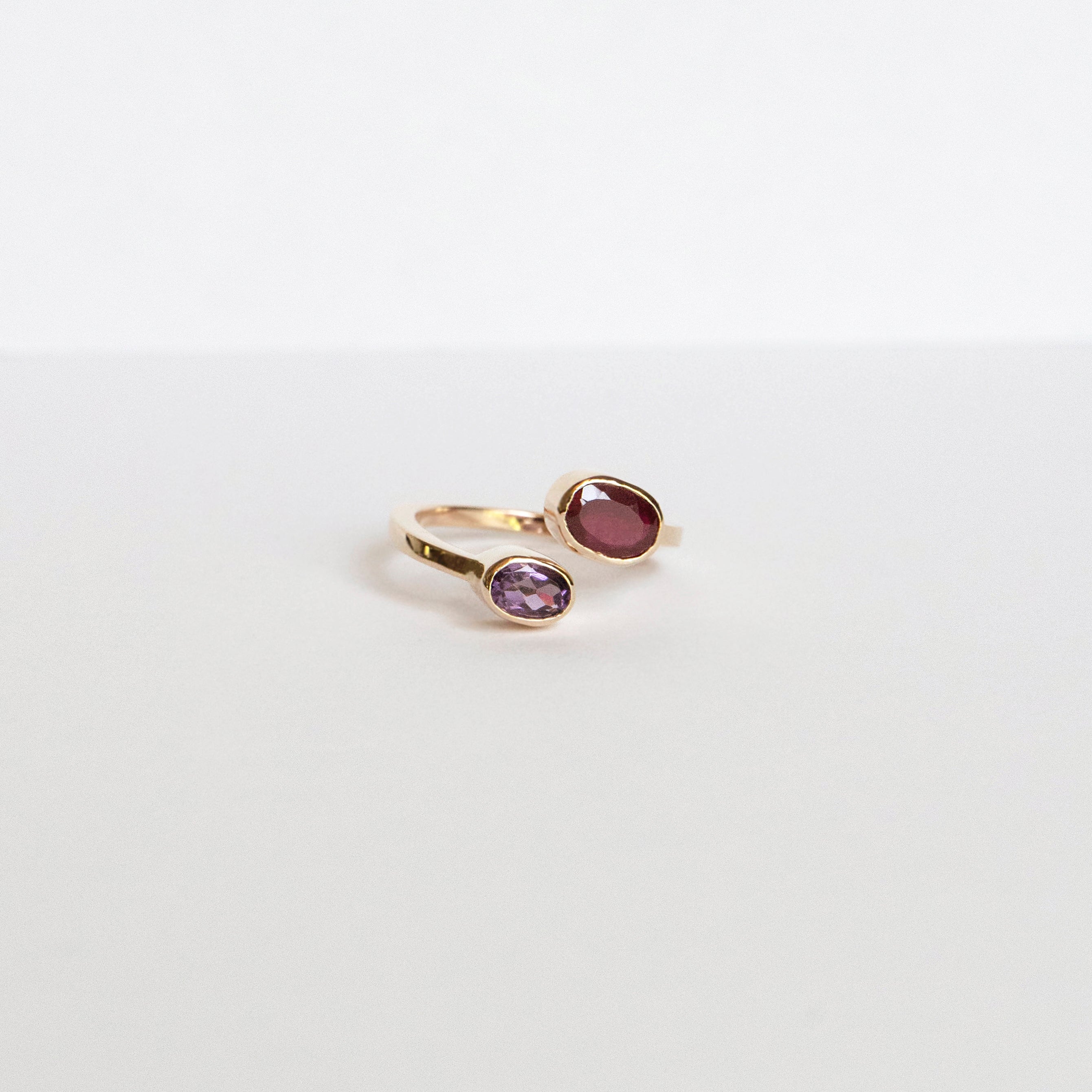 Oval ruby and amethyst bezel ring set east–west