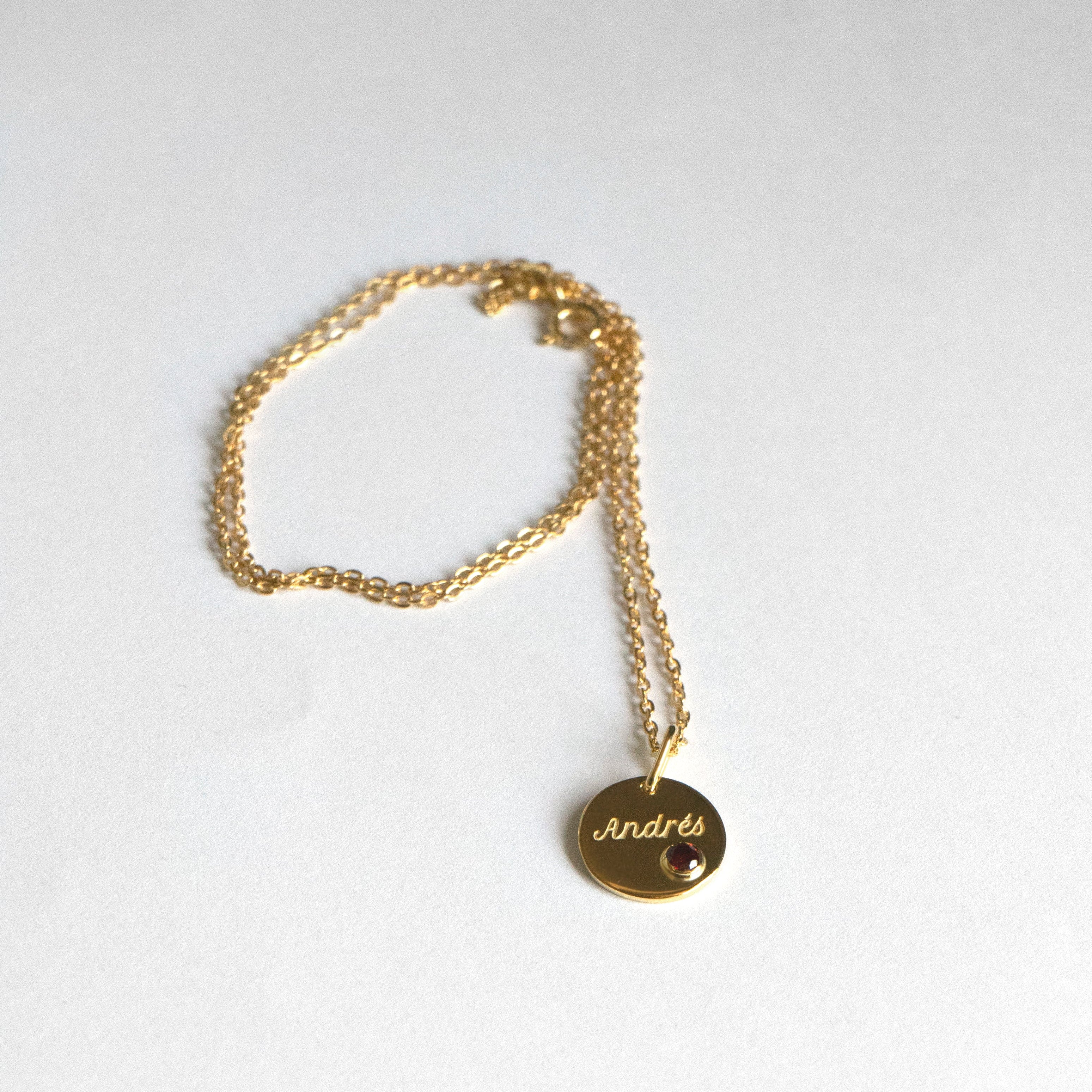 14k gold engraved round pendant necklace with bezel-set garnet