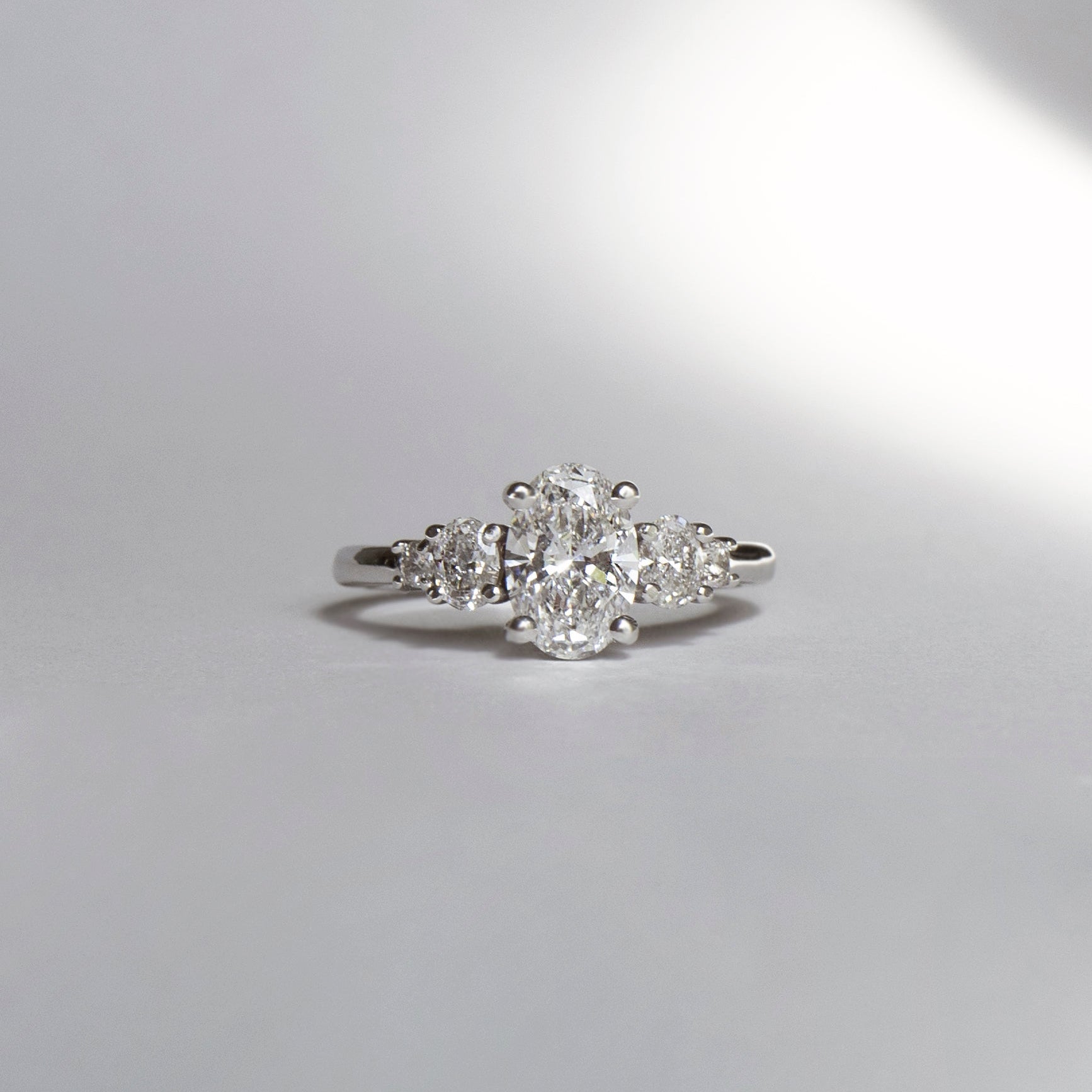 Oval diamond engagement ring with oval and round diamond accents