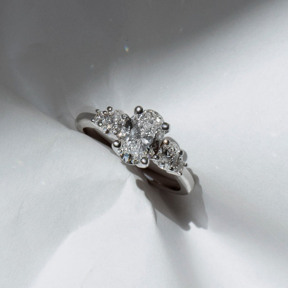 Oval diamond engagement ring with oval and round diamond accents