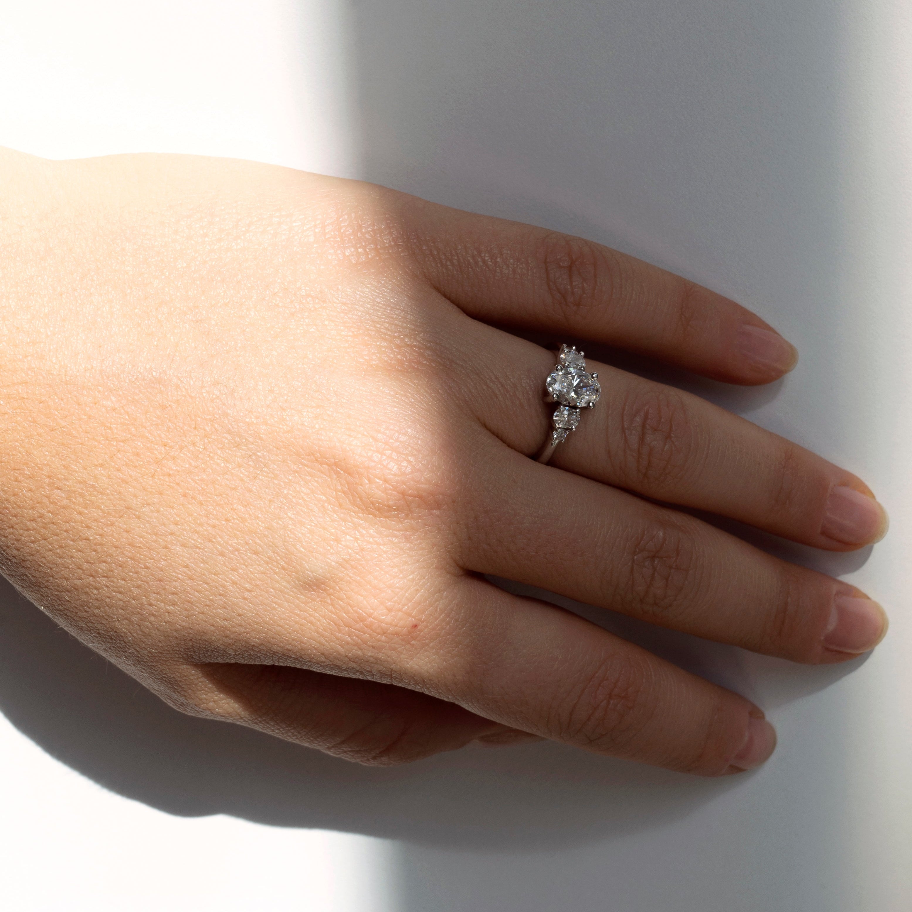 Oval diamond engagement ring with oval and round diamond accents