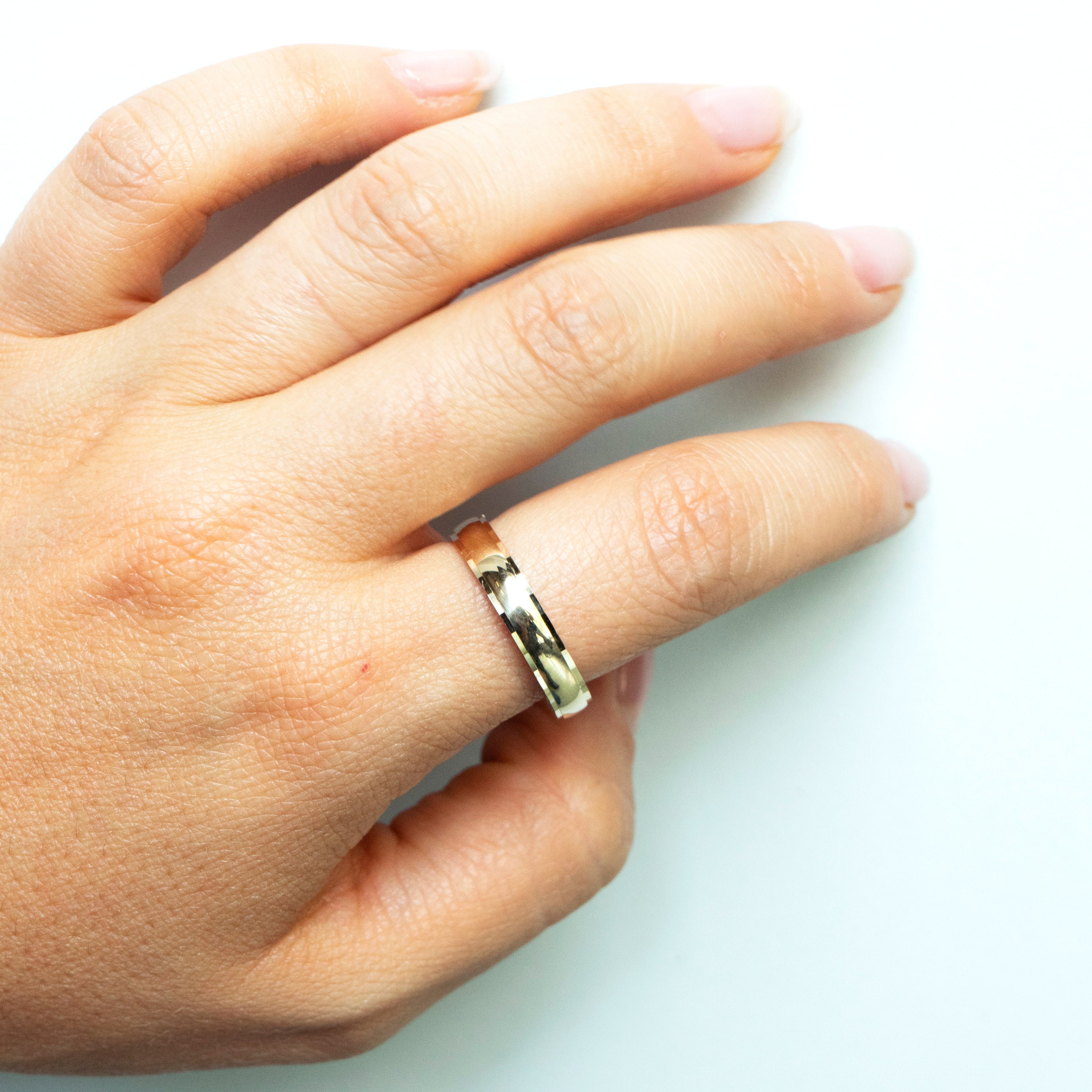 Yellow gold half-round wedding band with faceted edges and comfort-fit