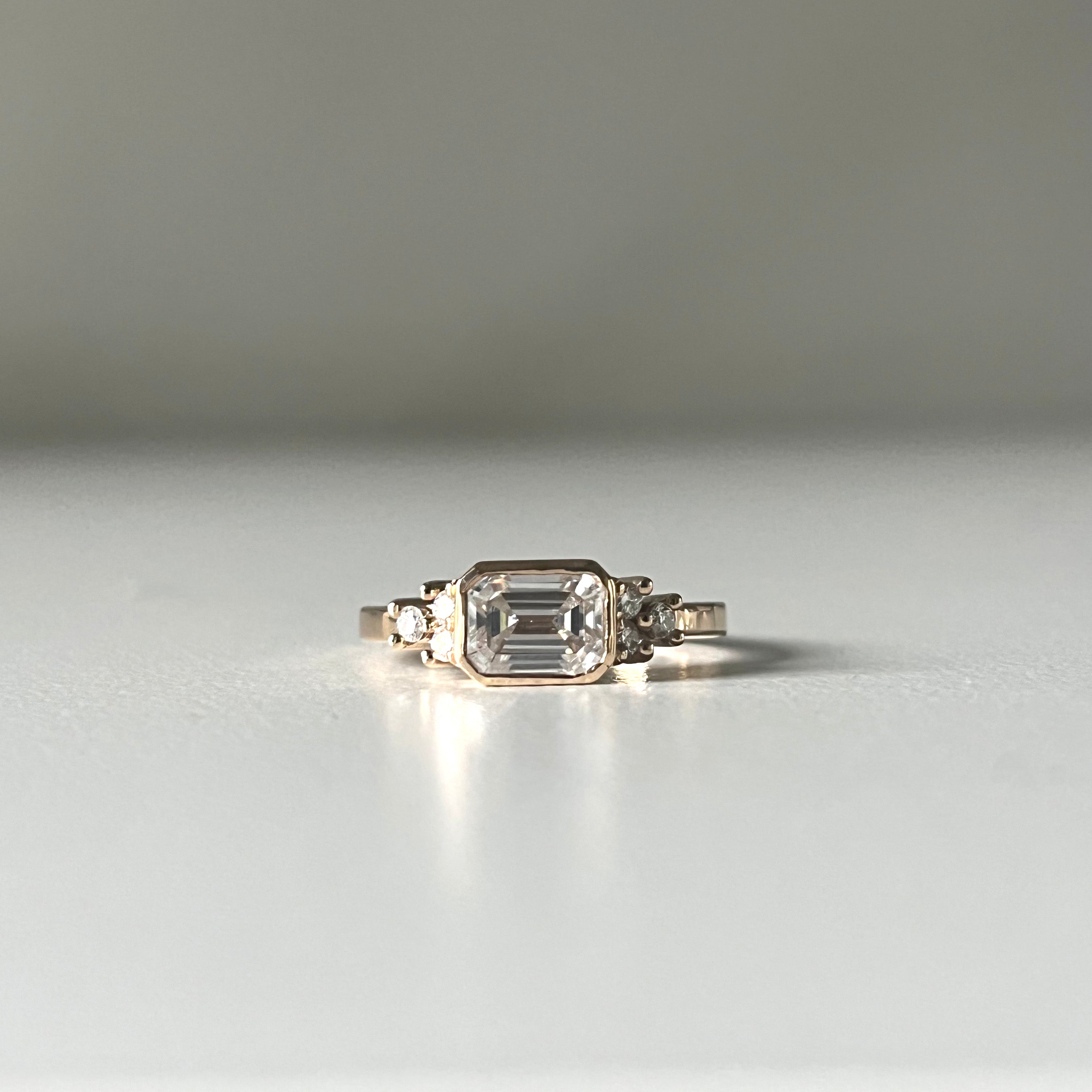 Anillo de compromiso con diamante corte esmeralda en bisel