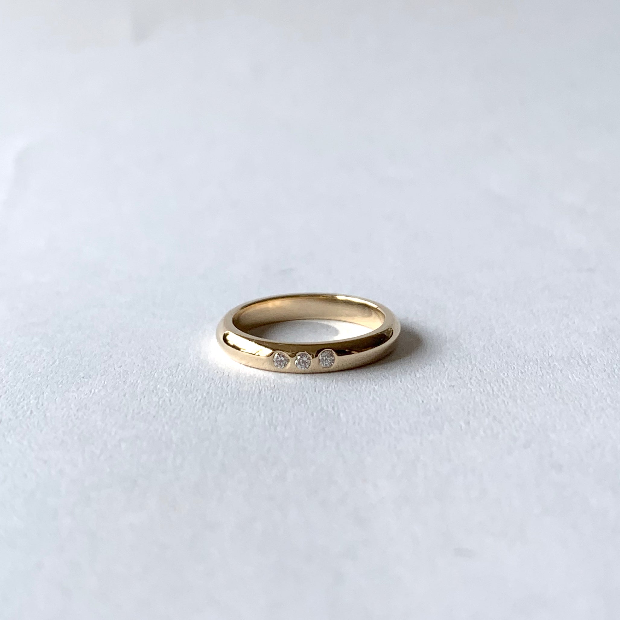 Yellow gold wedding band with three diamonds