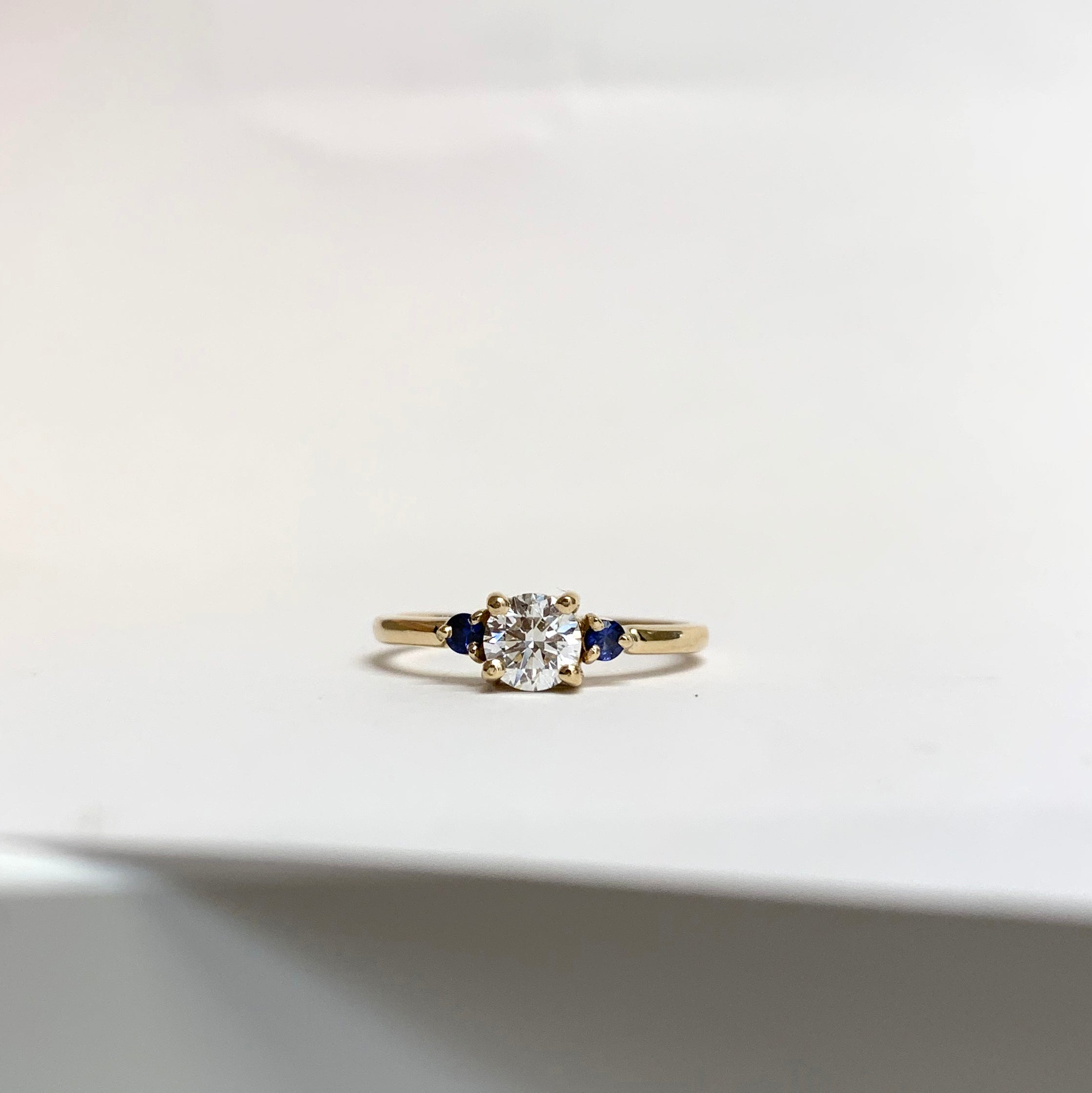Anillo de compromiso con diamante blanco y zafiros azules