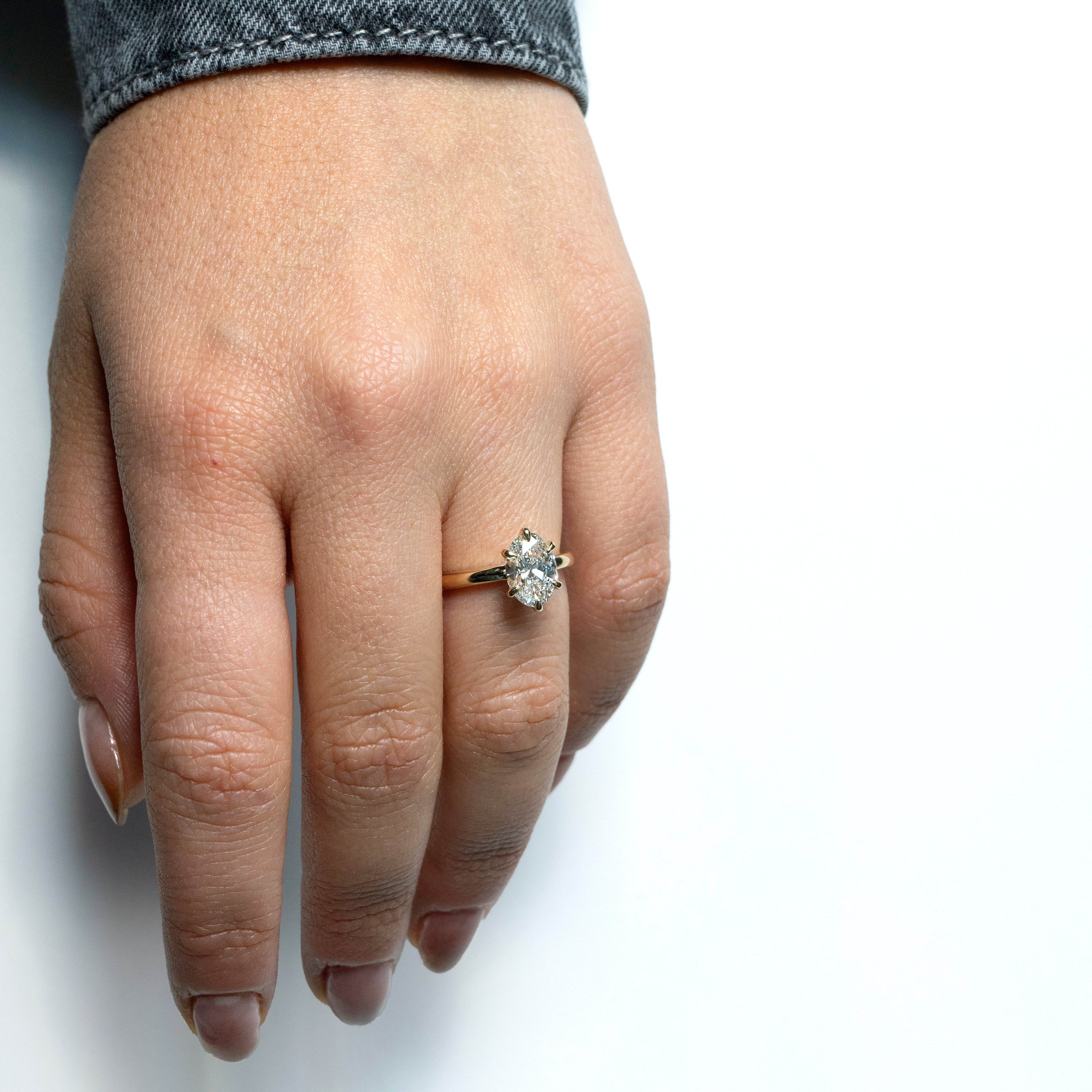 Oval lab-grown diamond solitaire engagement ring with six-pointed prongs in 14k yellow gold