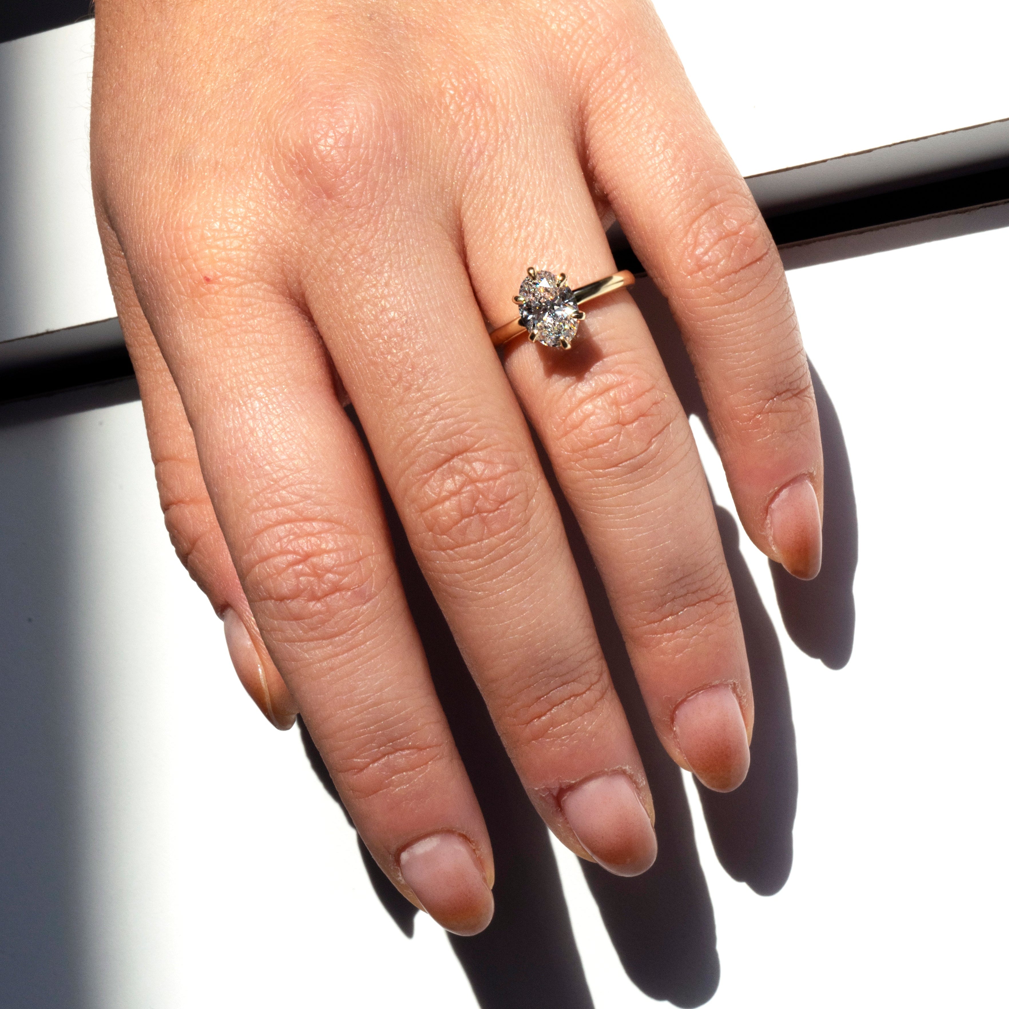 Oval lab-grown diamond solitaire engagement ring with six-pointed prongs in 14k yellow gold